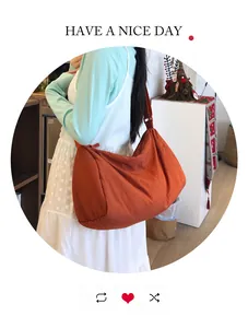 Detailed view of large orange nylon crossbody bag showing soft texture and spacious design