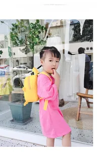 Toddler girl in pink habit T-shirt dress with a yellow dinosaur backpack for daily outings
