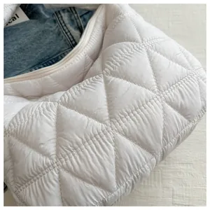 Detail of white quilted puffy shoulder bag with diamond stitching and zip closure