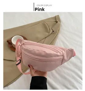 Detailed view of pink nylon crescent waist bag with adjustable strap and woven zipper pull