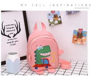 Detailed view of pink canvas dinosaur backpack for kids on a checkered tablecloth