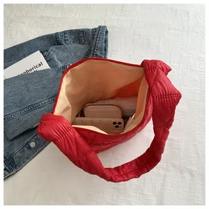 Top view of red quilted puffy bag showing spacious yellow interior with phone and wallet