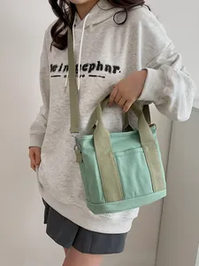 Borsa tote in tela verde menta con tracolla regolabile mostrata in uno stile di vita casual