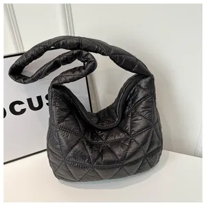 Close-up of black quilted puffer shoulder bag showing rhombus stitching and texture