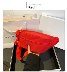 Close-up of bright red nylon chest bag with adjustable strap and textured zipper cord