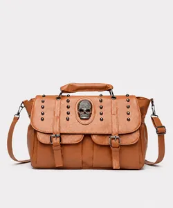 Detailed front view of brown leather bag with metallic rivets and skull emblem