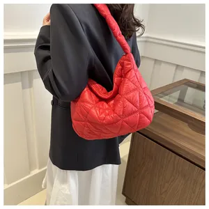 Close-up of red quilted nylon tote bag featuring puffy diamond lattice stitching detail