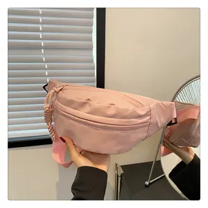 Detailed view of pink nylon crossbody bag with adjustable strap and textured fabric