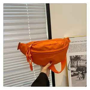 Detail of bright orange nylon waist bag with woven rope zipper and adjustable strap