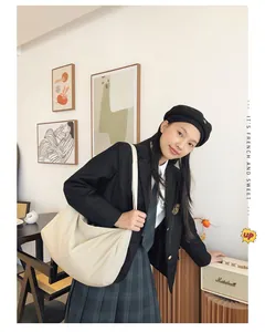 Detail of a large cream beige nylon shoulder bag with wide strap for travel and daily use