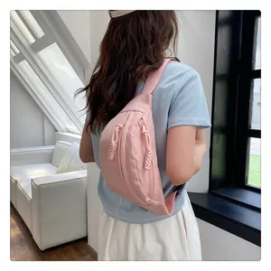Detailed view of pink nylon chest bag with woven rope zippers on a female model