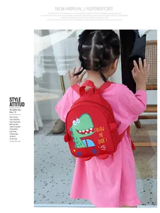 Detail of red kids canvas bag featuring a green cartoon dinosaur and adjustable strap