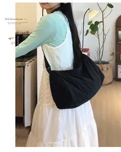 Detailed shot of a black large capacity nylon crescent crossbody bag worn with casual outfit