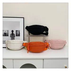 Minimalist waterproof nylon waist bags in black, white, orange and pink on acrylic stands