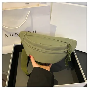 Detailed macro view of olive green nylon crossbody bag with textured zipper pull cord
