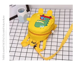 Close-up of kids yellow canvas bag with dinosaur prints and adjustable chest straps