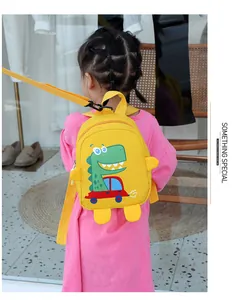 Detail view of yellow toddler backpack with dinosaur print and safety leash strap