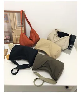 Flat lay of colorful nylon crescent crossbody bags in various colors on a modern desk