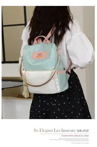 Vue détaillée du sac à dos en tissu Oxford avec pompon et bretelles rayées tendance