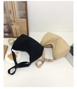 Nylon crescent shoulder bags in black and beige displayed in a modern urban lifestyle setting