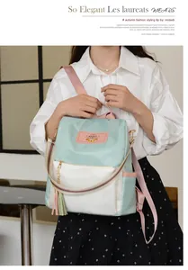 Détail du sac à dos Oxford bleu clair avec bretelles colorées et pompons décoratifs