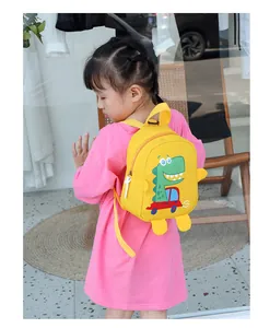 Detail of yellow canvas kids backpack with a cartoon dinosaur pattern and a 3D decorative part