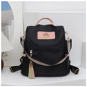 Détail du sac à dos noir en tissu Oxford avec accents roses et bandoulière tissée