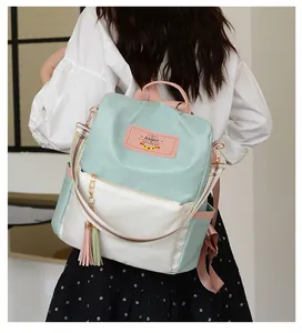 Vue détaillée du sac à dos oxford vert menthe et blanc avec sangles roses et gland