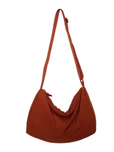 Minimalist large nylon crescent crossbody bag in brick red with adjustable strap