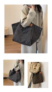 Detalle de bolso tote grande de lona con estampado de leopardo, remaches y bolsillo frontal