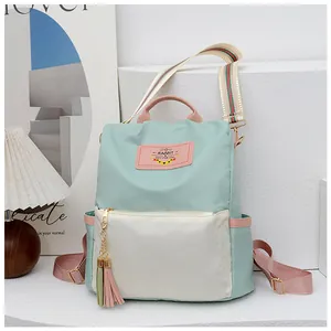 Détail d'un sac à dos en tissu Oxford imperméable avec design tricolore et pompon décoratif