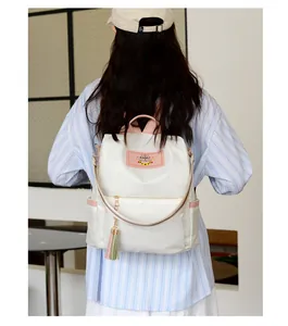 Détail d'un sac à dos en nylon imperméable avec glands et étiquette en cuir rose