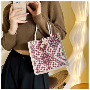 Close-up of ethnic canvas tote with woven texture, rope handles and wooden button detail