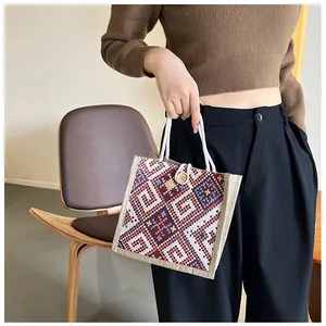 Close-up of ethnic canvas tote with geometric woven patterns and rustic rope handles