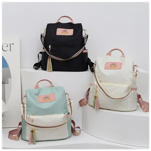 Trois sacs à dos en tissu Oxford noir, crème et vert avec bretelles arc-en-ciel