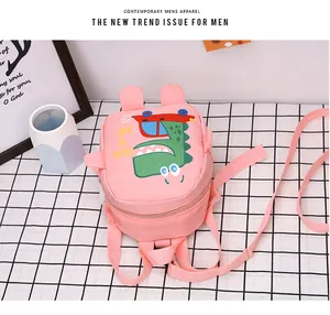 Close-up of pink canvas dinosaur bag featuring cute cartoon patterns and soft ears