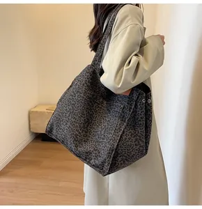 Primer plano del bolso tote de lona con estampado de leopardo y remaches metálicos