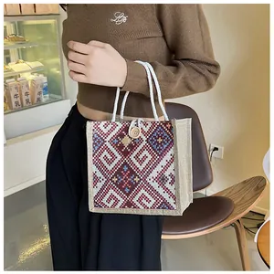 Close-up of ethnic embroidery and wooden button closure on canvas tote bag