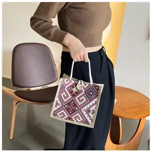 Detailed embroidery and wooden button closure on ethnic canvas tote with rope handle