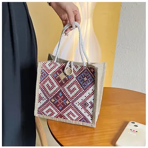 Detailed close-up of woven geometric patterns and jute texture on ethnic handbag