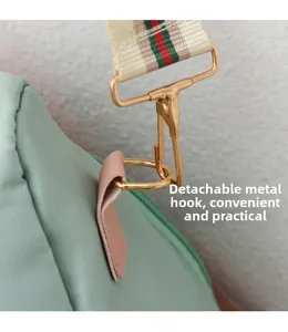 Détail du crochet en métal et de la bandoulière rayée sur le sac à dos oxford vert