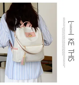 Détail du sac à dos en nylon blanc cassé avec poignées roses et bretelles arc-en-ciel