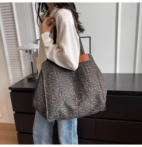Detalle de un bolso tote grande de lona con estampado de leopardo y etiqueta de cuero