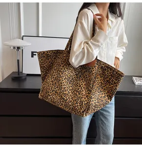 Detalle macro de bolso tote de lona con estampado de leopardo y remaches metálicos