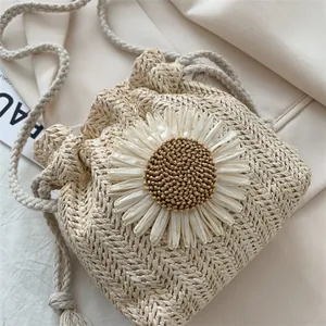 Handwoven straw bucket bag with large daisy flower and drawstring closure for summer