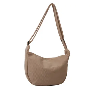 Minimalist khaki corduroy crossbody bag featuring a chic crescent moon shape and adjustable strap
