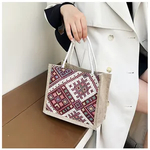 Detailed embroidery on ethnic style linen tote bag with woven rope handle
