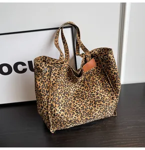 Primer plano detallado de un bolso tote grande de lona con estampado de leopardo y cuero