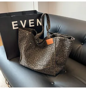 Bolso tote de lona con estampado de leopardo y parche de cuero naranja en sofá