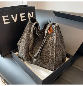 Detalle del bolso tote grande con estampado de leopardo y remaches en caja de regalo